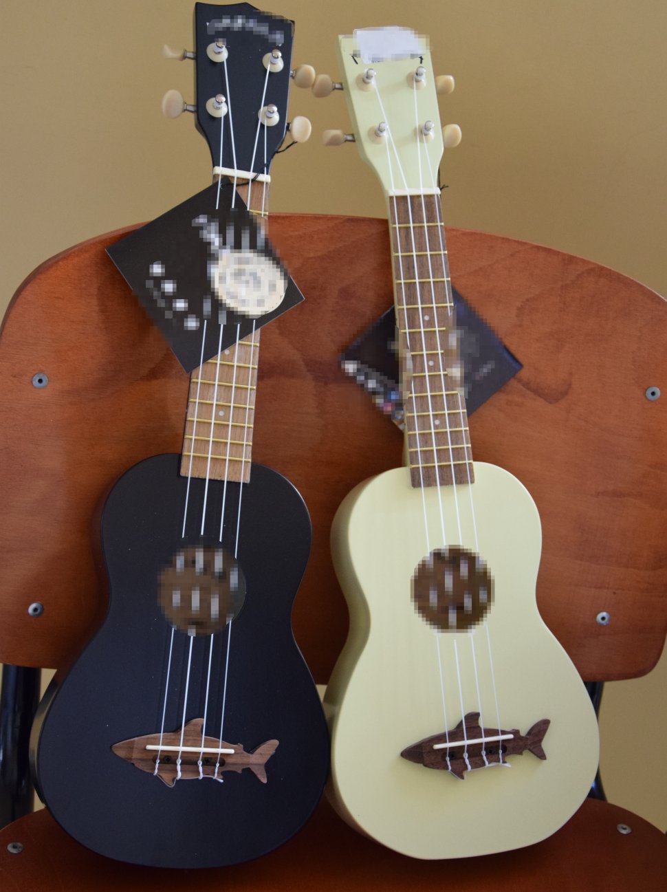 zdjęcie kolorowa: na zdjęciu widać 2 sztuki ukulele w kolorze czarnym i białym