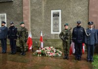 Zdjęcie przedstawia wartę honorową pod tablicą upamiętniającą pomordowanych z Kozielska, Ostaszkowa, Starobielska i innych obozów, którą pełnili tarnogórscy policjanci wraz z żołnierzami oraz funkcjonariuszami straży więziennej.