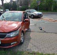 Zdjęcie przedstawia dwa rozbite samochody osobowe. Pojazdy zderzyły się na skrzyżowaniu ulic.