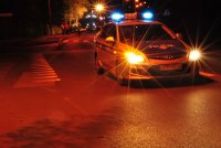 zdjęcie przedstawia policyjny radiowóz z włączonymi sygnałami świetlnymi