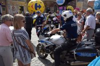 na fotografii widać policjanta na motorze, który znajduje się w tłumie ludzi
