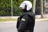 Na fotografii widać policjanta. Mundurowy ubrany jest w kamizelkę przeciwuderzeniową  i hełm.