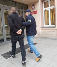 policjant prowadzi zatrzymanego, wchodzą do Prokuratury Rejonowej w Tarnowskich Górach