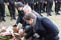 Przedstawiciele Starostwa Powiatowego oraz Poseł na Sejm Tomasz Głogowski kładą pod tablicami pamięci wiązanki z kwiatami