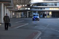 fotografia kolorowa: policyjny radiowóz przemieszcza się przez dworzec autobusowy
