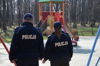fotografia kolorowa: dwoje policjantów obserwuje plac zabaw