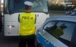na fotografii widać policjanta, który stoi naprzeciwko autokaru