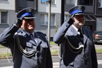 Na fotografii widać dwóch komendantów, którzy oddają honor przed tablicą upamiętniającą poległych policjantów