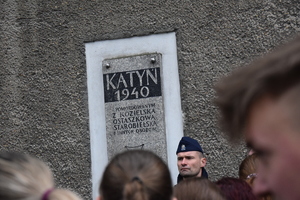 na zdjęciu tablica na murze z napisem katyń 1940 pomordowanym z kozilska ostaszkowa starobielska i innych obozów, po nią policjant