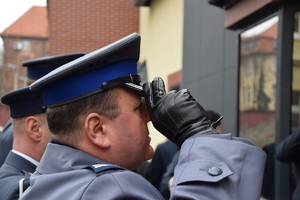 na zdjęciu komendant policji oddający honor pod pamiątkową tablicą