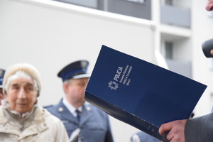 na zdjęciu niebieska teczka trzymana w rękach osoby z napisem komenda powiatowa policji w Tarnowskich Górach
